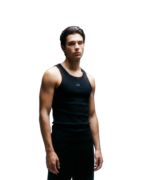 Man wearing a black tank top against a gradient blue background