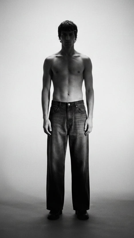 Man wearing dark jeans against a gradient background